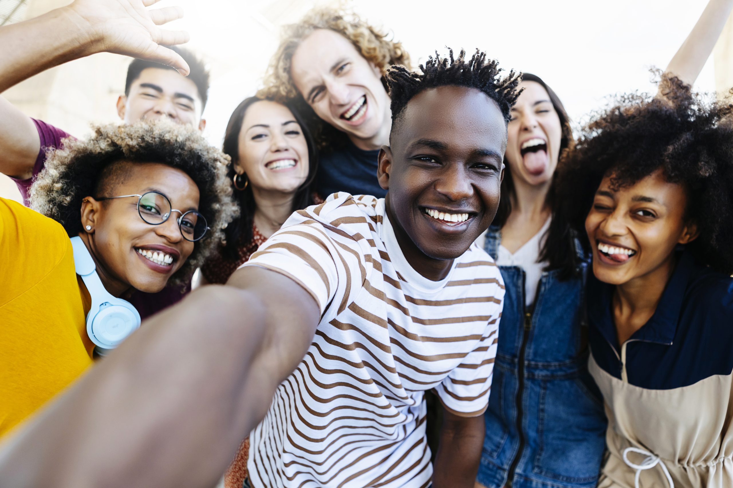 Group of multiracial happy best friends taking selfie photo with smartphone camera